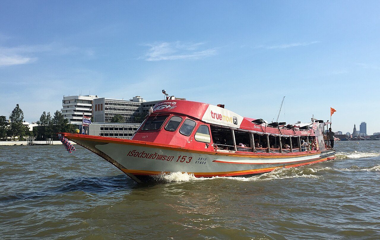 Chao Phraya express boat in Bangkok with เรือด่วนเจ้าพระยา painted on the hull and an orange flag at the stern