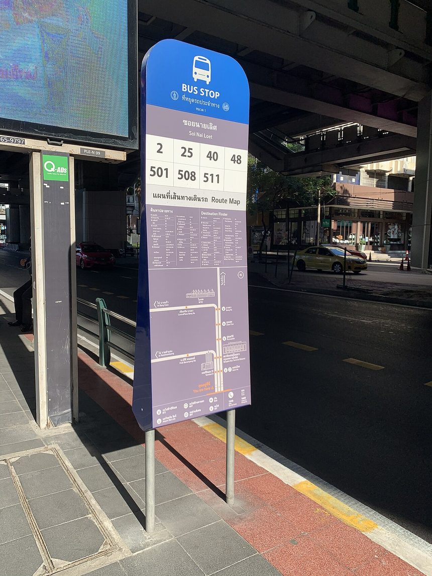 Bangkok bus stop sign in Thai script reading ที่หยุดรถประจำทาง with the stop name ซอยนายเลิศ Soi Nai Loet, route numbers and a destination map