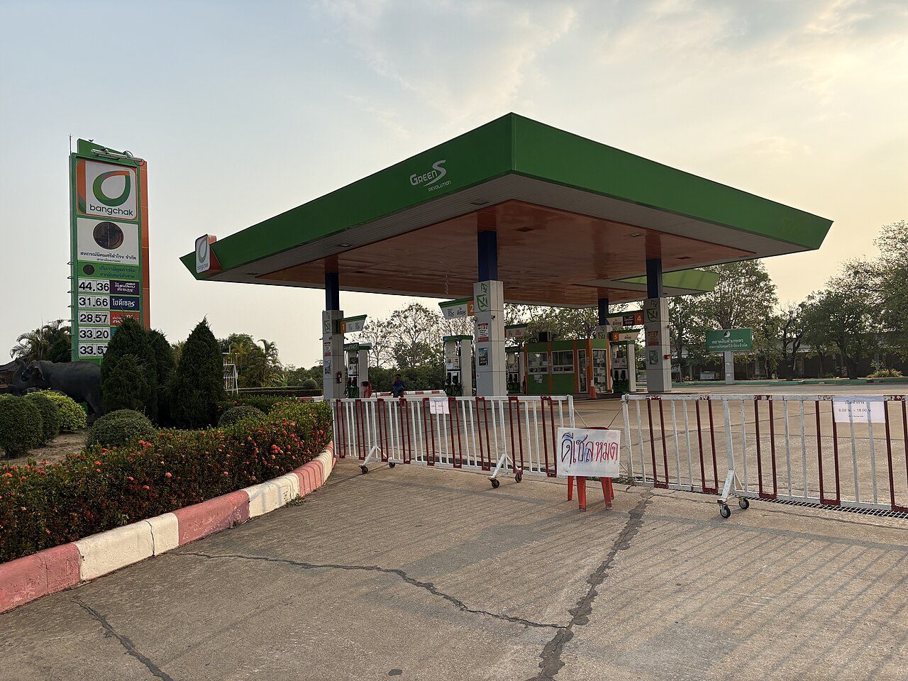 Closed Bangchak petrol station in Sukhothai, Thailand, with a hand-written Thai sign reading diesel sold out