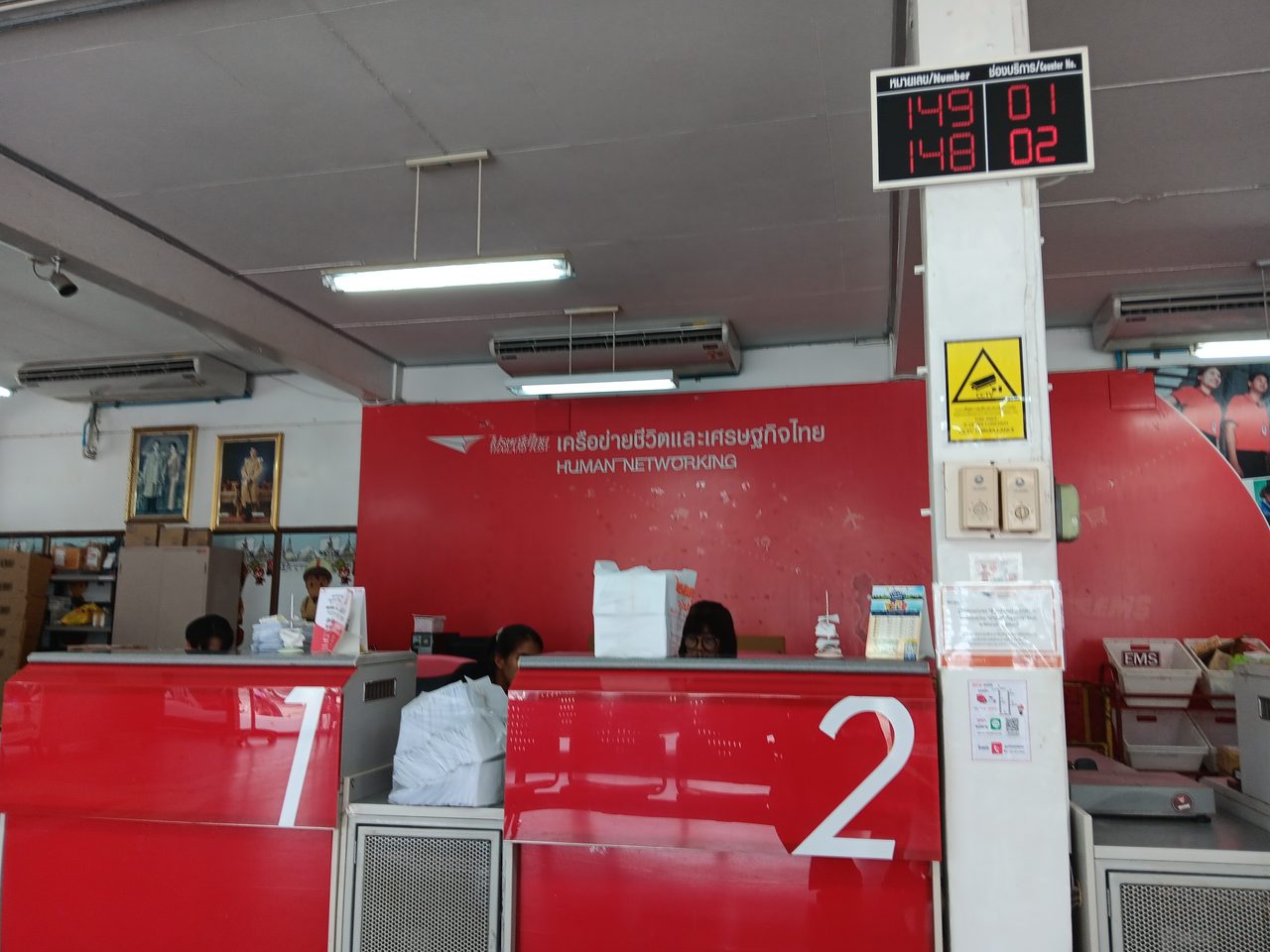 Thailand Post service counters at Thung Song post office with a Thai queue number display reading maai-lek and chong borikan