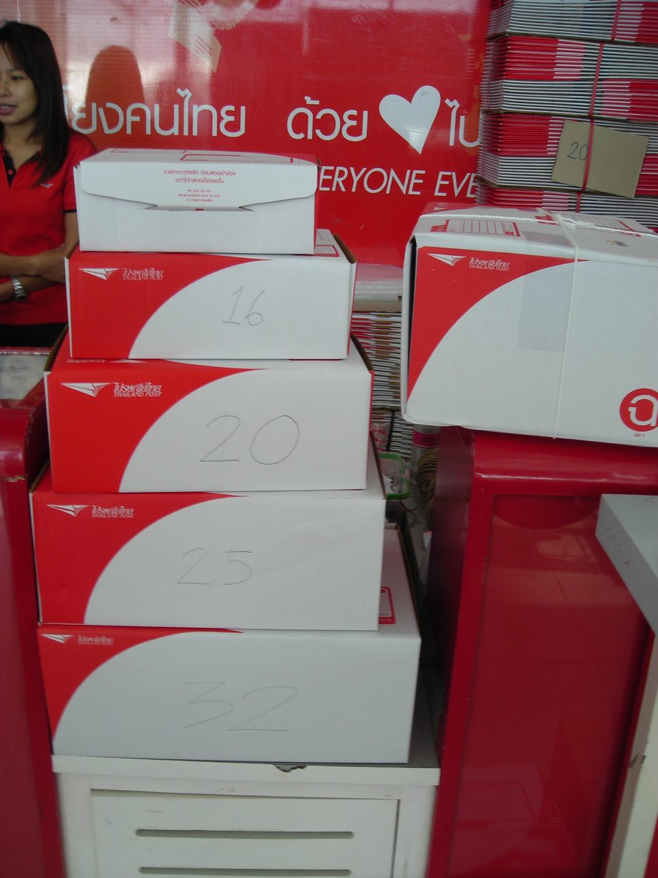 Stack of Thailand Post cardboard parcel boxes for sale, each marked with its size number, under the Thai praisani thai logo
