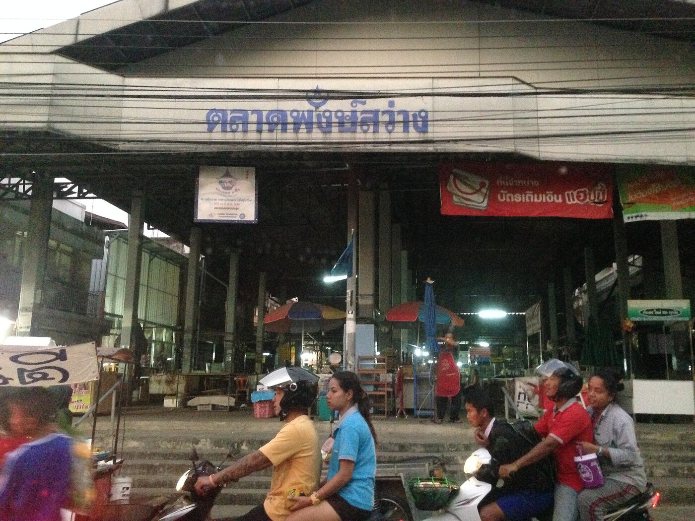 Blue Thai script sign reading talat over the entrance of a fresh morning market in Muak Lek Saraburi Thailand, a practical way to read Thai script