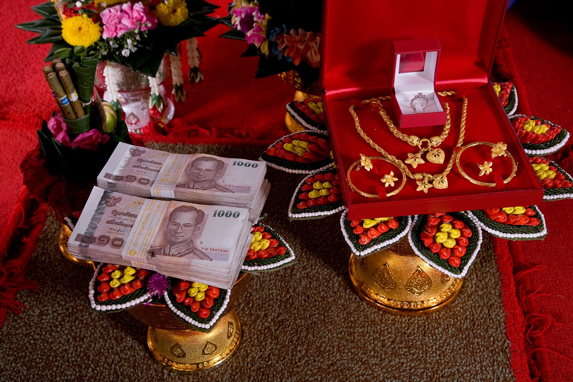 Thai sin sot bride price of 1000 baht banknotes and engagement gold displayed on gold phan trays at a Thai engagement ceremony