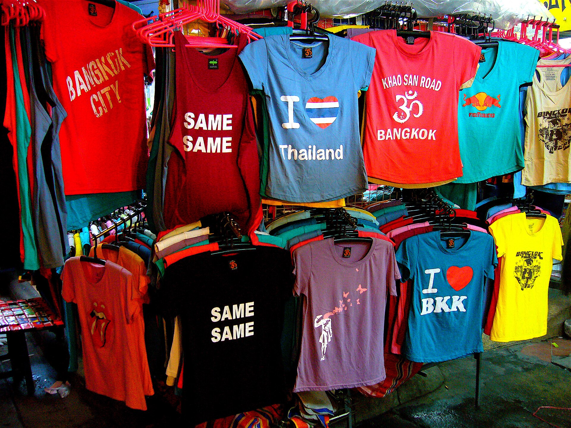 Rack of printed souvenir T-shirts on red hangers at a market stall on Khao San Road in Bangkok, Thailand